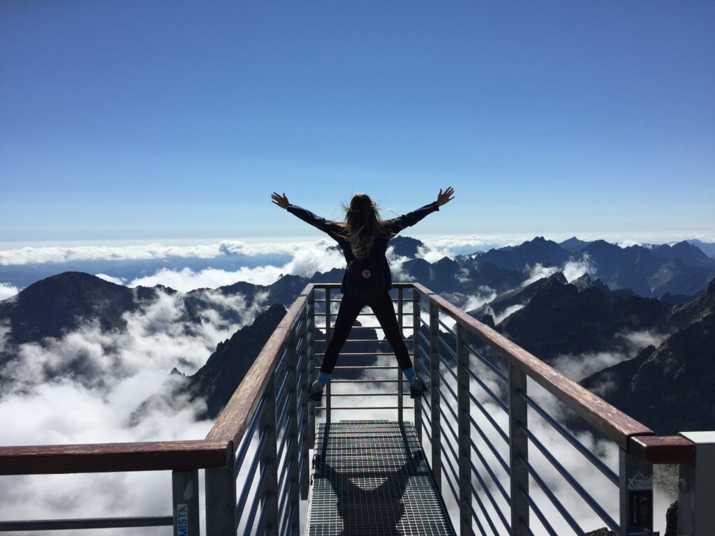 jeune femme en haut d'un massif montagneux, sur un ponton